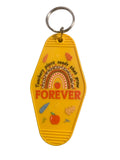 Yellow keychain with 'FOREVER' text and decorative elements on a gray surface