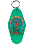 Green keychain with rainbow, apple, hearts, and text 'TEACH LOVE INSPIRE' on a beige background