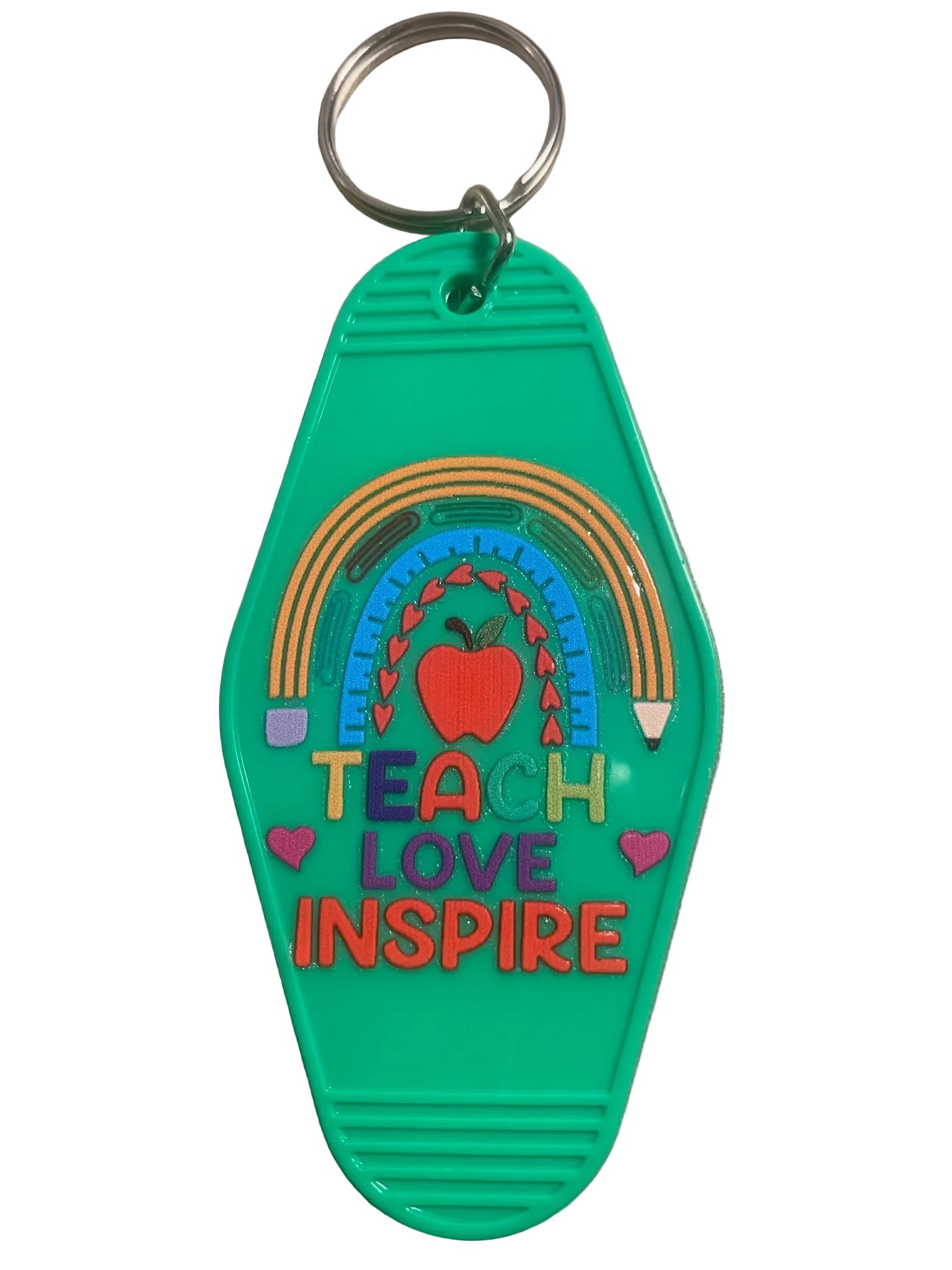 Green keychain with rainbow, apple, hearts, and text 'TEACH LOVE INSPIRE' on a beige background